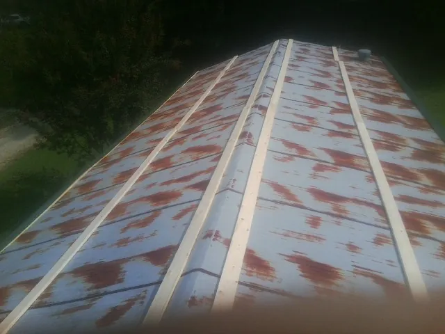 Rusted metal roof panels with new wood purlins before replacement — Storm Damage Roof Repair in Wildwood by Roofing Brothers