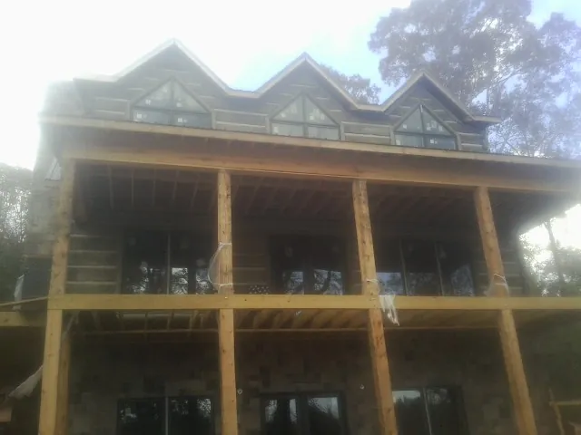 Dormers and porch framing on a large log home under construction — Roof Coating work by our crew in Wildwood